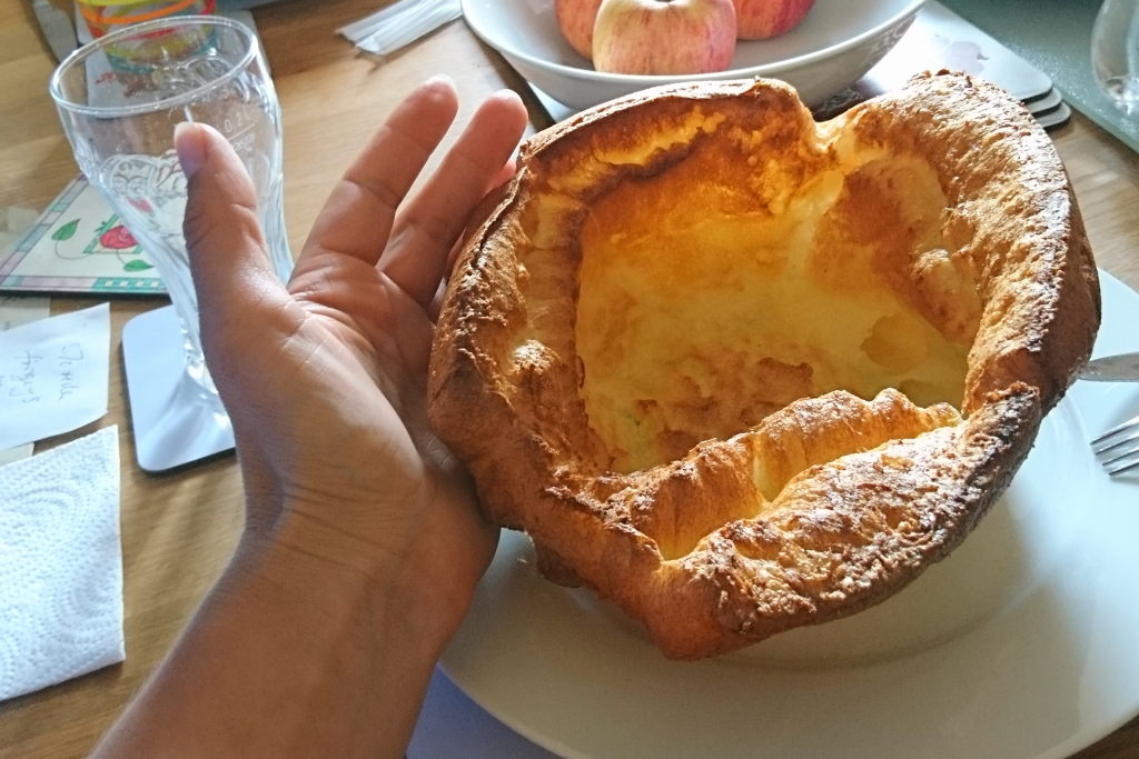 Ein riesiger Yorkshire Pudding mit einer Hand daneben