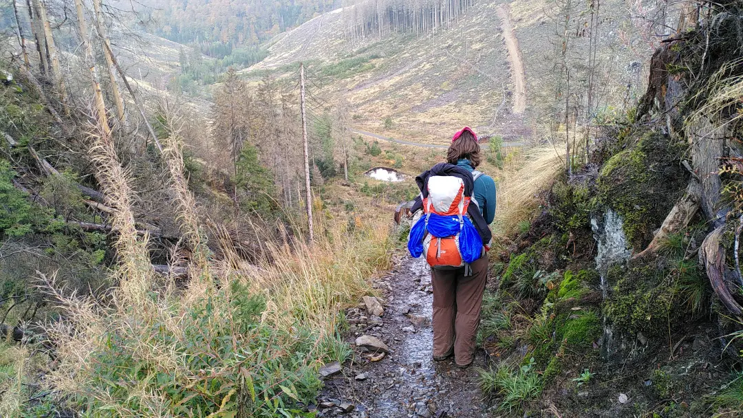 Manu on a narrow, muddy footpath overlooking the valley we were descending into