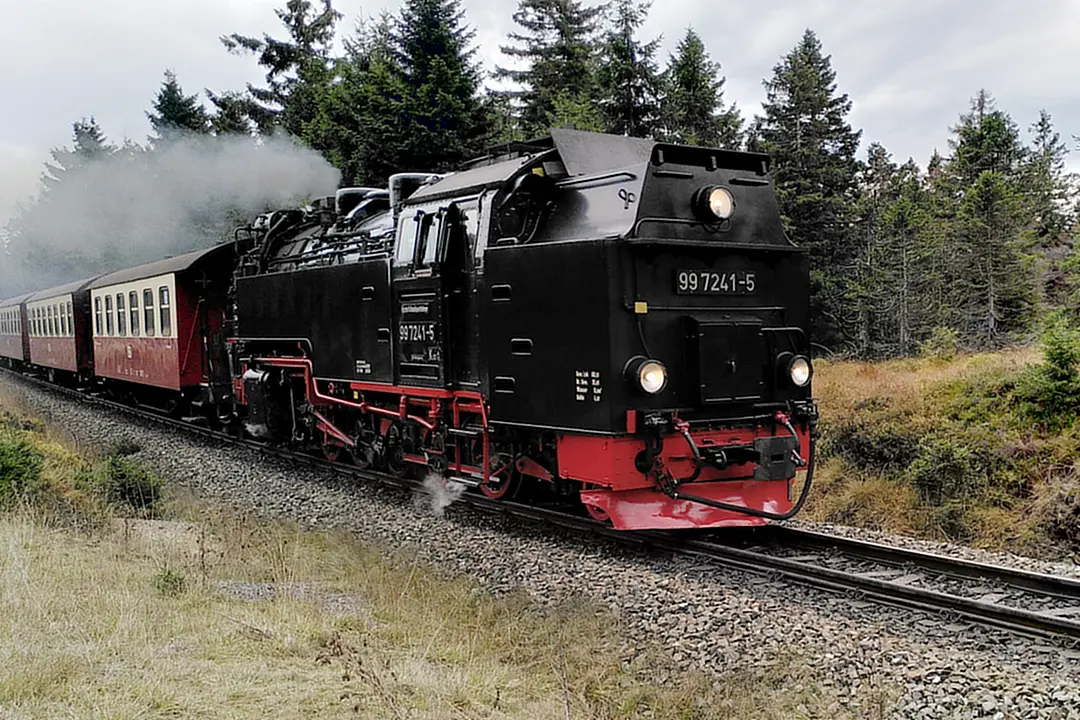 The steam locomotive of the Brocken Railway pulling its cars up the mountain