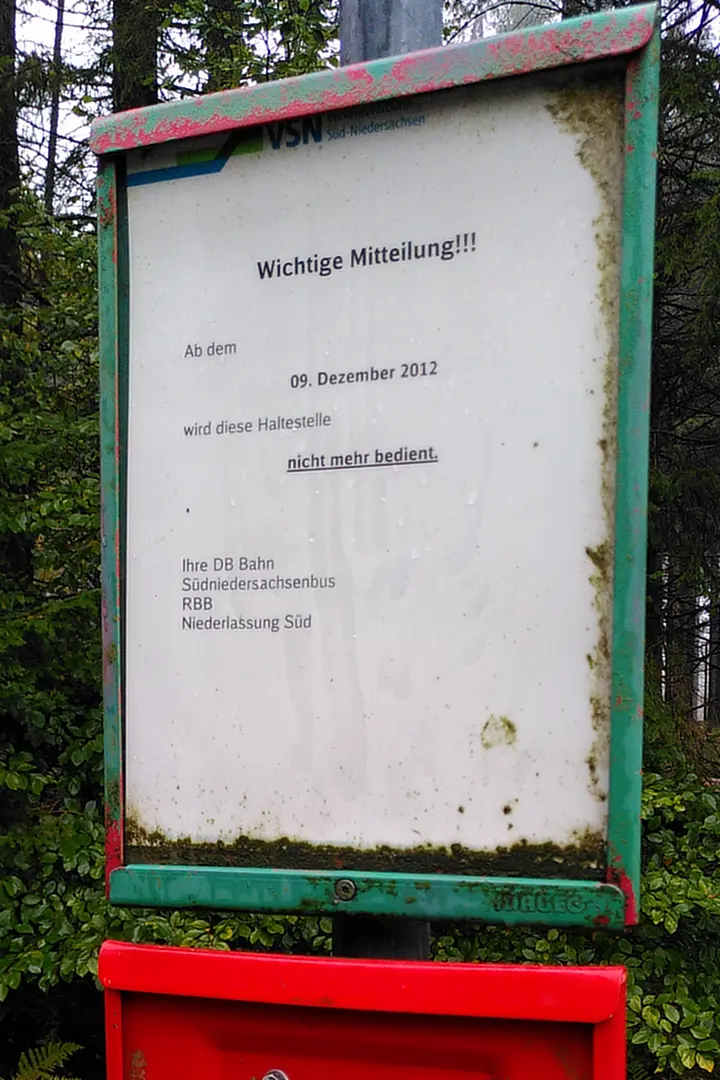 An old bus stop sign with a note that the bus line hasn't operated since 2012