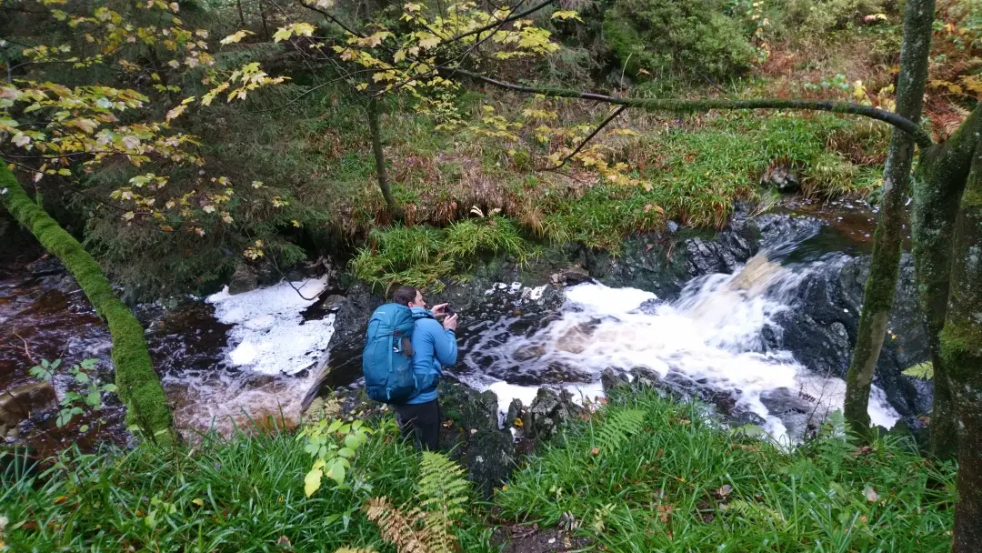 Markus crouched over the stream trying to get a photo of the water
