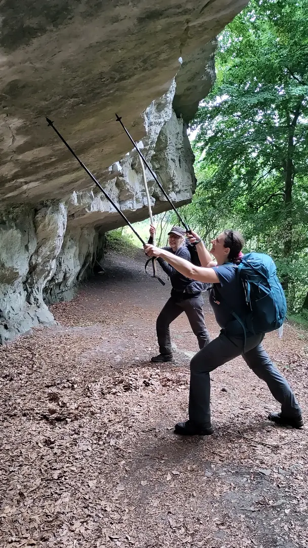 Manu und Lütti stüzen einen Felsüberhang mit ihren Wanderstöcken ab