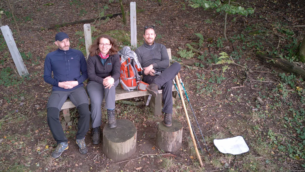 Marcus, Manu and Markus on a bench in the forest, photographed from above
