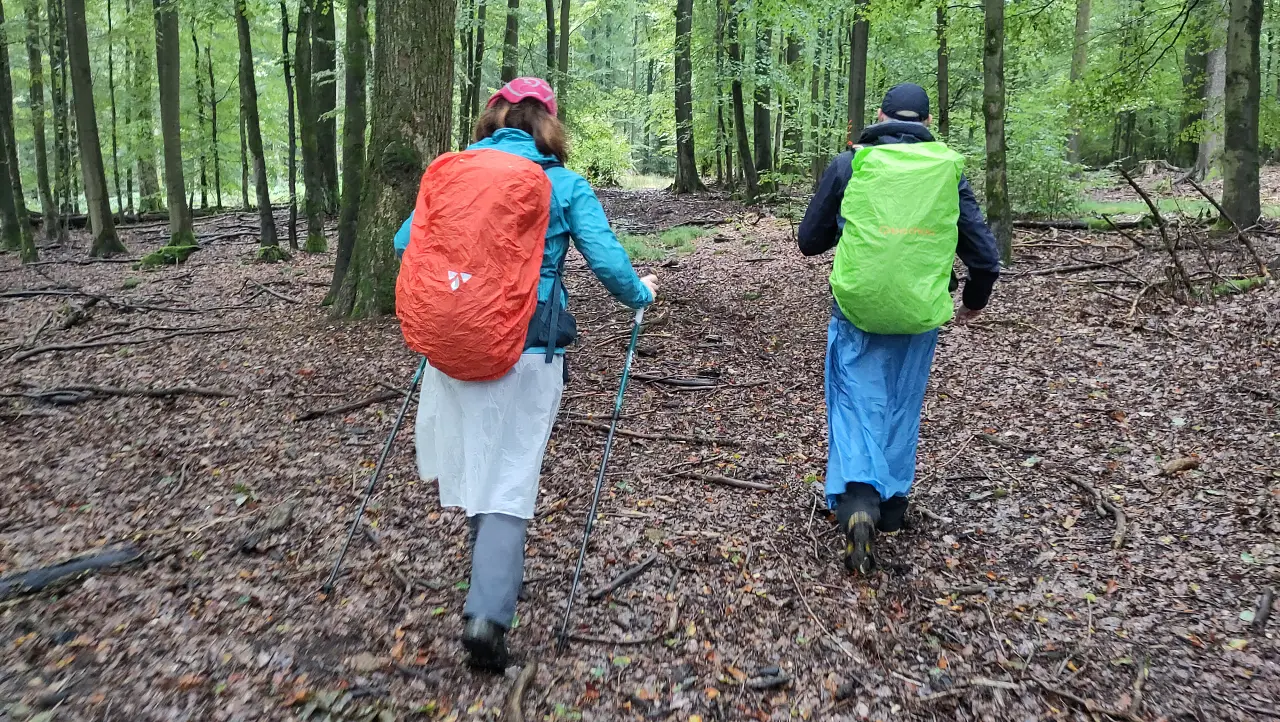 Marcus and Manu bundled up in colorful rain gear in the forest