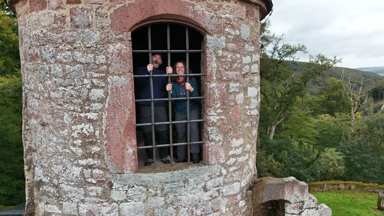 Manu and Marcus inside the tower of the Schönrain ruins behind bars, photographed by the drone from outside